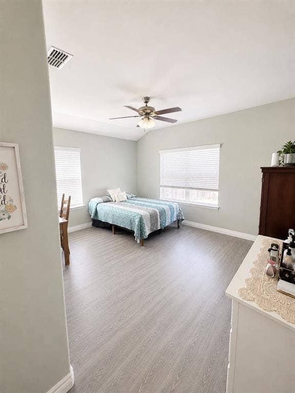 714 N Wofford Street, Athens, TX 75751 Vaulted ceiling with a ceiling fan light fixture, wood-finish flooring, and multiple windows with blinds