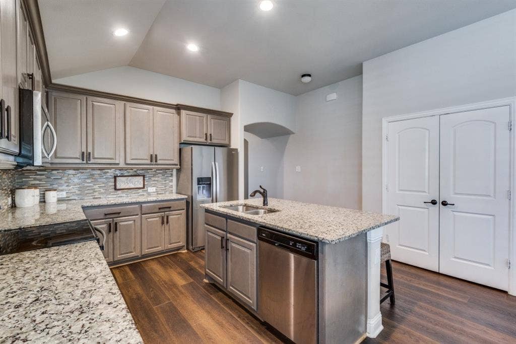 6911 Truth Drive, Dallas, TX 75236 Kitchen featuring wood-finish flooring, recessed lighting, a kitchen island with sink, and white paneled double doors
