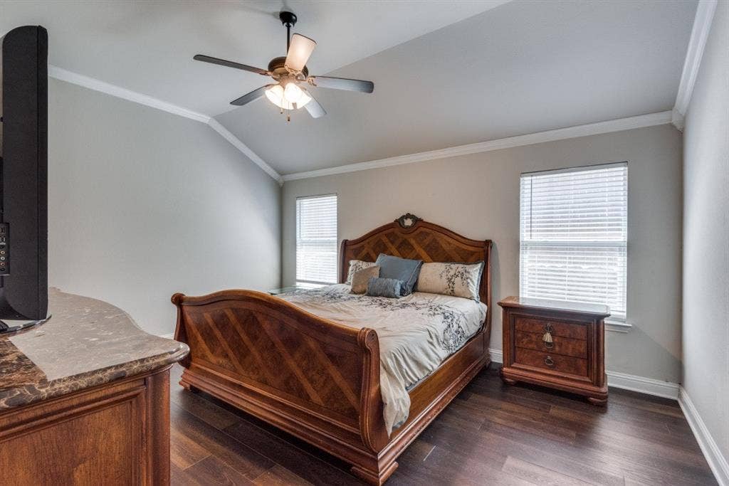 6911 Truth Drive, Dallas, TX 75236 Vaulted ceiling with crown molding, wood-finish flooring, and two windows with blinds