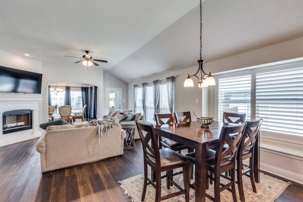 6911 Truth Drive, Dallas, TX 75236 Expansive living area featuring wood-finish flooring, a white mantel fireplace, and a ceiling fan