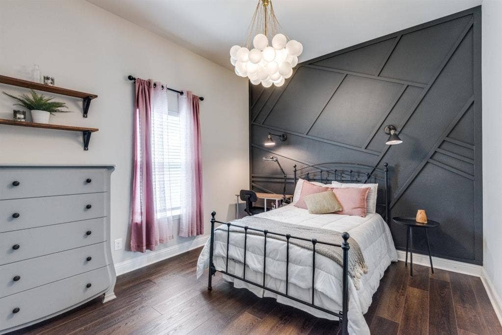 6911 Truth Drive, Dallas, TX 75236 Accent wall with geometric molding, wood-finish flooring, built-in wall sconces, ceiling-mounted light fixture, and window with blinds