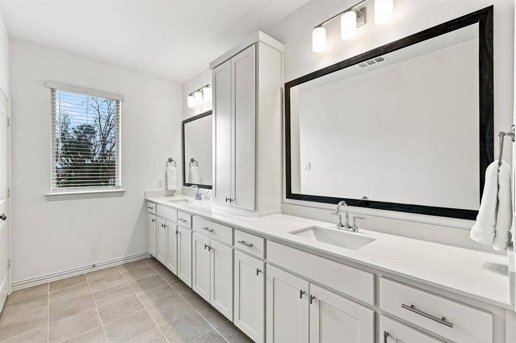 4833 Lunker Street, McKinney, TX 75071 Bright and beautifully appointed, the primary bath offers dual sinks, extensive counter space, generous storage, and natural light.