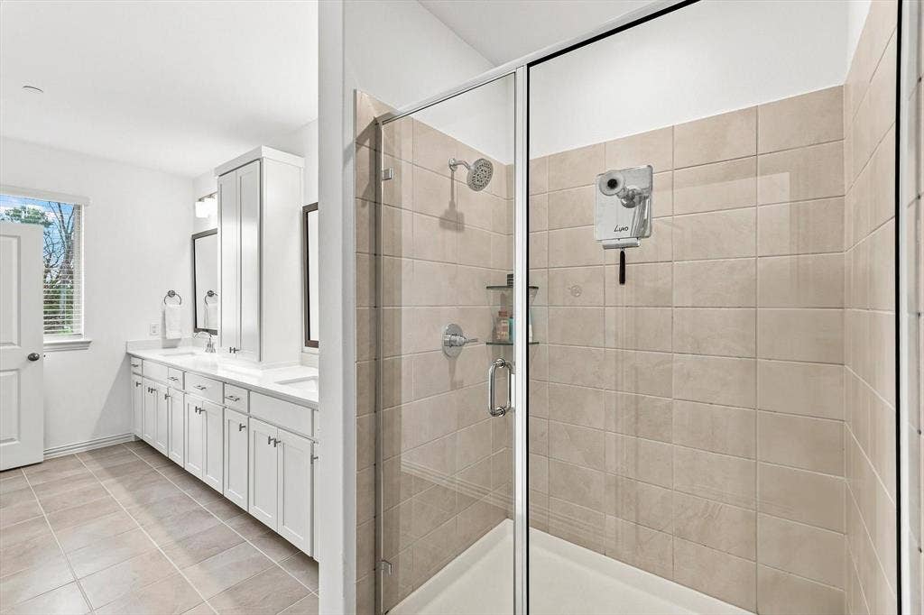 4833 Lunker Street, McKinney, TX 75071 A relaxing finish to the primary suite. The spacious glass-enclosed shower features neutral tile and a clean, timeless design.