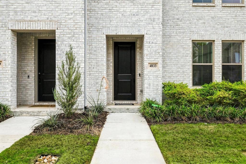 4833 Lunker Street, McKinney, TX 75071 Welcome home. The bold black entry door against classic white brick creates a timeless, sophisticated entrance.