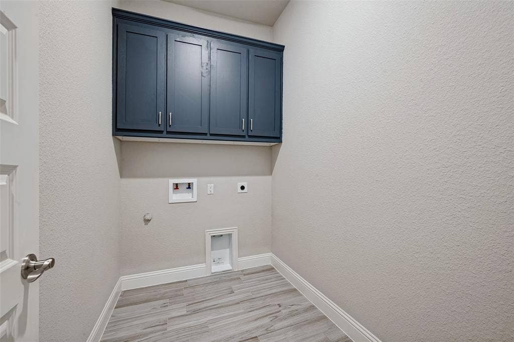 6001 Allison Drive, Midlothian, TX 76065 Built-in cabinetry with dark blue shaker-style cabinets help to conceal all your laundry supplies.
