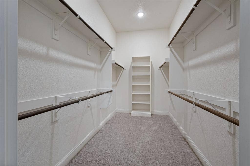 6001 Allison Drive, Midlothian, TX 76065 Walk-in closet with carpet flooring, built-in shelving, white walls and hanging space for your long items of clothing.