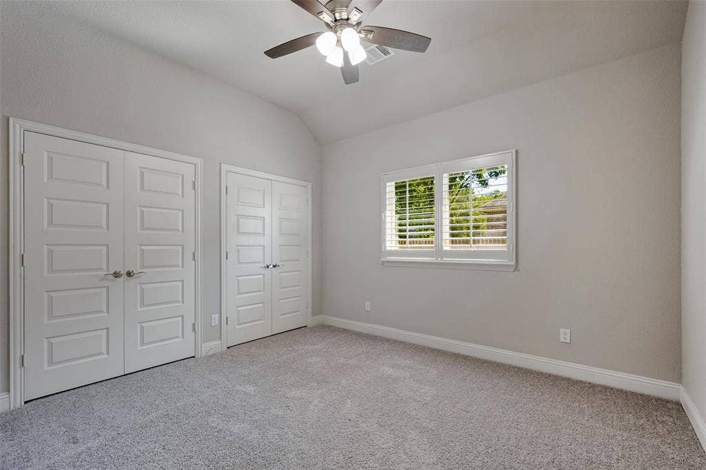 6001 Allison Drive, Midlothian, TX 76065 Carpeted bedroom featuring a ceiling fan, a window with plantation shutters and spacious connecting closets.