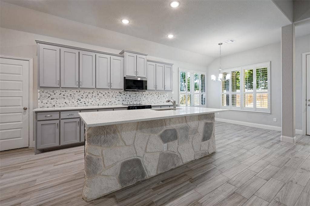 6001 Allison Drive, Midlothian, TX 76065 The kitchen opens to the living area and the breakfast nook. The windows are adorned with plantation shutters and open to the backyard.