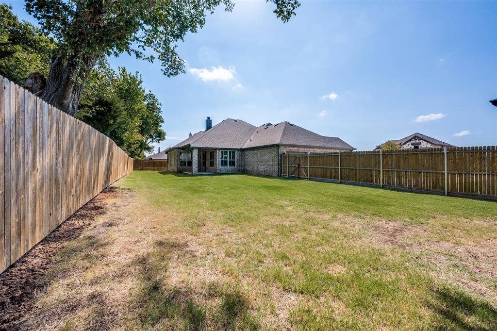 6001 Allison Drive, Midlothian, TX 76065 A look at the house from the far Northwest Corner of the yard. There is plenty of room to enjoy outdoor activities.