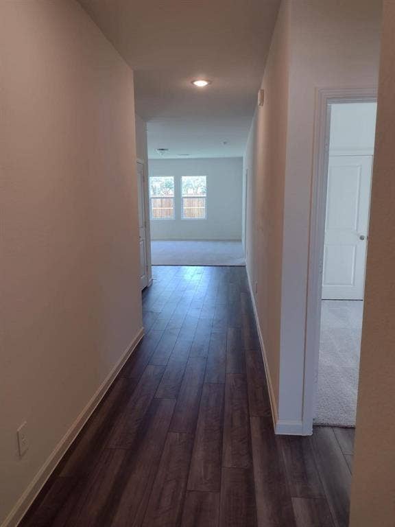 Hallway featuring wood-finish flooring, recessed lighting, and neutral wall paint