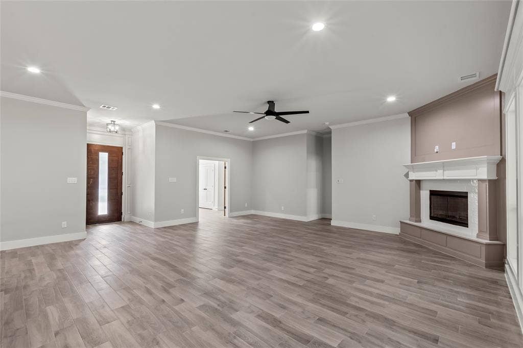 128 Saint Andrews Drive E, Mabank, TX 75156 Spacious living area featuring wood-finish flooring, recessed lighting, and a corner fireplace with a white mantel