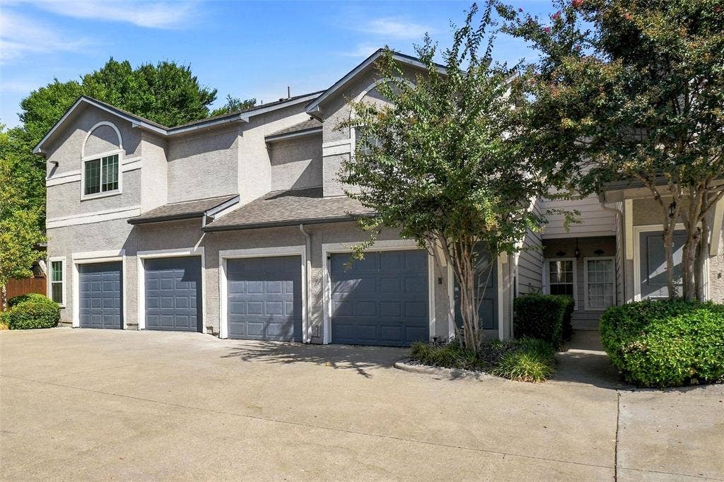 2601 Preston Road, #4103, Plano, TX 75093 Stucco exterior with multiple garage doors, arched window detail, and mature landscaping