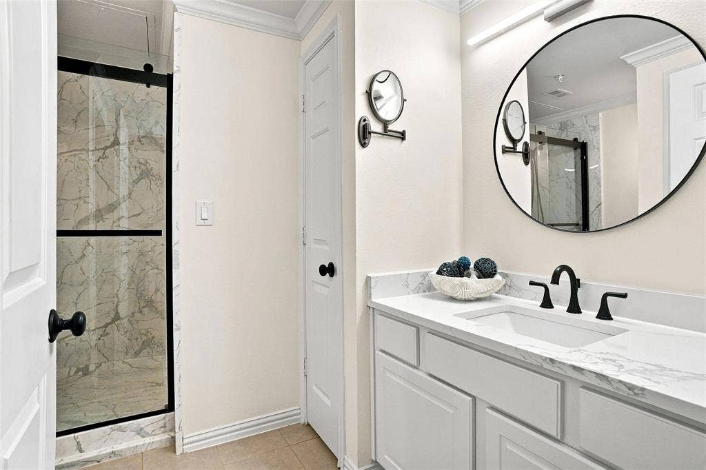 2601 Preston Road, #4103, Plano, TX 75093 Shower with sliding glass enclosure, marble-style tile surround, and black hardware