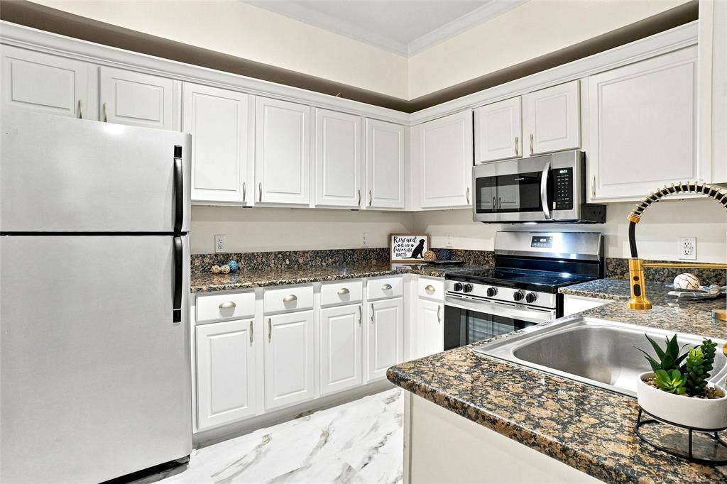 2601 Preston Road, #4103, Plano, TX 75093 Kitchen featuring white cabinetry, granite-style countertops, stainless steel appliances, and a stainless steel sink with a flexible faucet