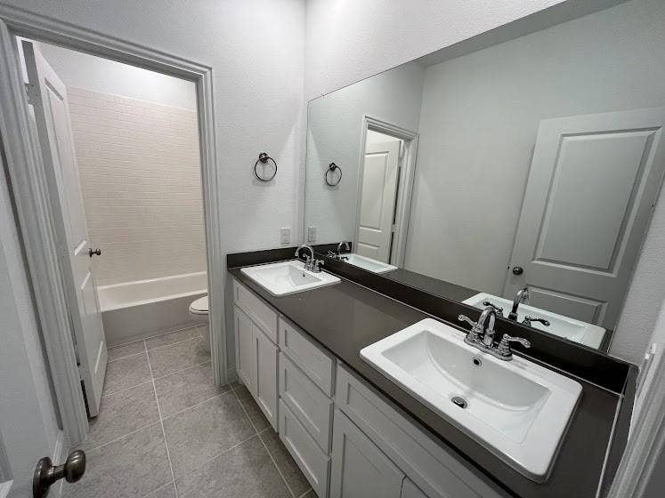 1408 Rendyn Street, Anna, TX 75409 Double vanity with integrated sinks, dark countertop, and chrome fixtures