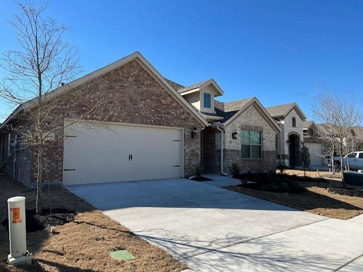 1408 Rendyn Street, Anna, TX 75409 Brick and stone exterior with dormer window accents, attached garage, and concrete driveway