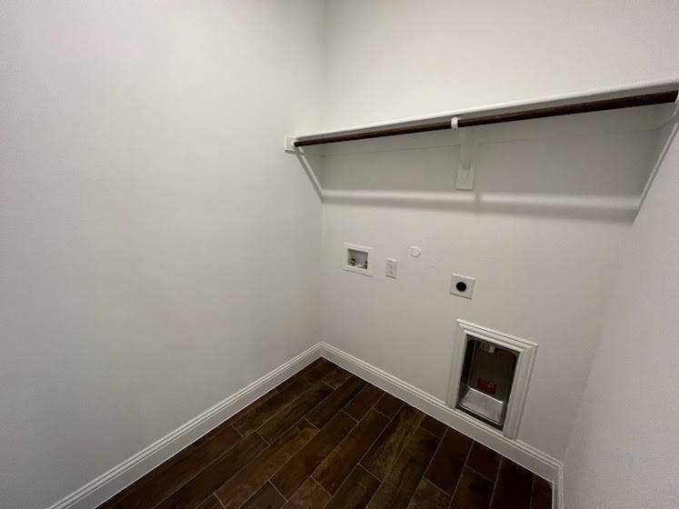 1408 Rendyn Street, Anna, TX 75409 Utility room featuring wood-finish flooring, white painted walls, a pet door opening, electrical outlets, and a retractable drying rack mounted above