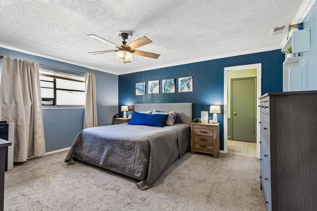 Recessed window with natural light, ceiling fan with integrated lighting, built-in shelving, wood-finish flooring, and crown molding