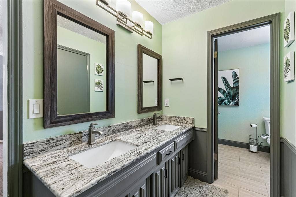 Double vanity with undermount sinks, stone countertop, and two framed mirrors