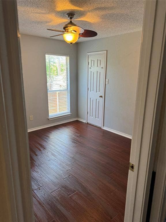 1025 Boardwalk Street, Midlothian, TX 76065 Spare room featuring a textured ceiling, ceiling fan, and dark hardwood / wood-style flooring