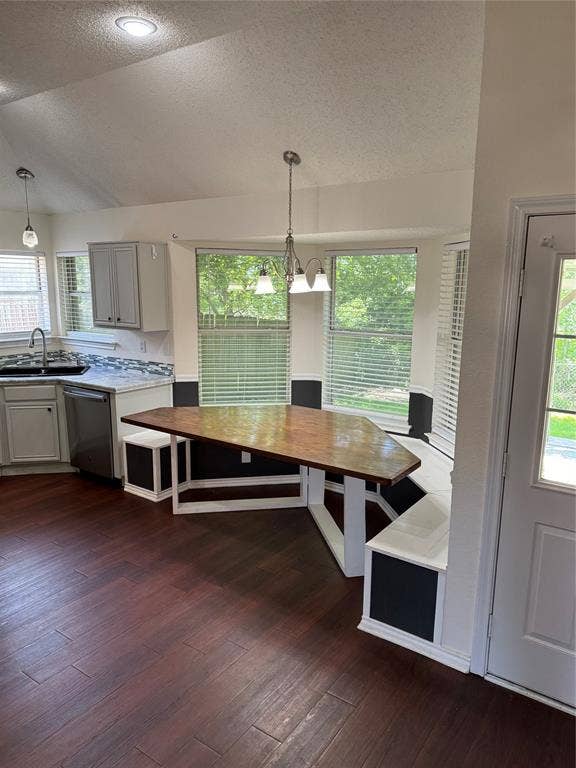 1025 Boardwalk Street, Midlothian, TX 76065 Unfurnished dining area featuring a textured ceiling, sink, dark hardwood / wood-style floors, vaulted ceiling, and an inviting chandelier