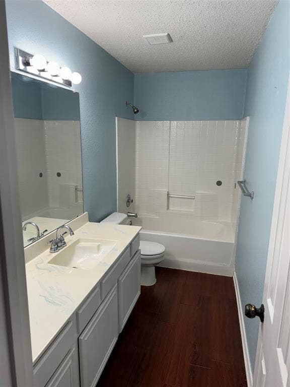 1025 Boardwalk Street, Midlothian, TX 76065 Full bathroom featuring vanity, hardwood / wood-style floors, bathtub / shower combination, toilet, and a textured ceiling