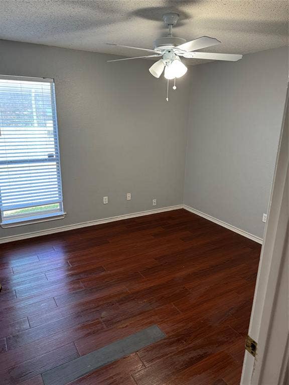 1025 Boardwalk Street, Midlothian, TX 76065 Empty room featuring dark hardwood / wood-style flooring, ceiling fan, and a textured ceiling