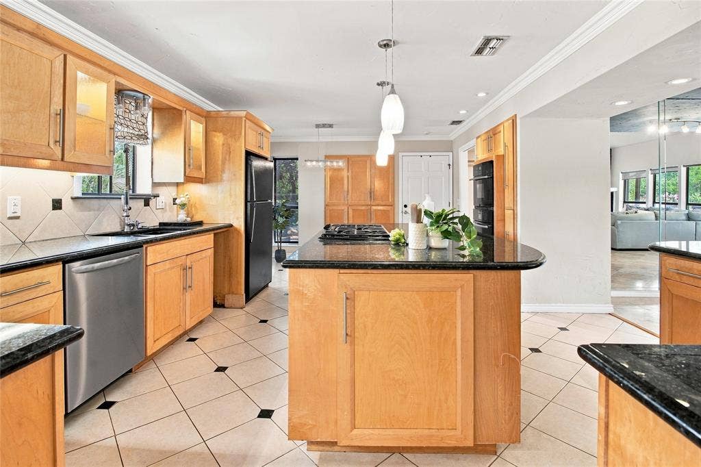 1417 Sun Valley Drive, Garland, TX 75043 Kitchen featuring light wood cabinetry, dark countertops, built-in stainless steel appliances, and a central island with an integrated cooktop