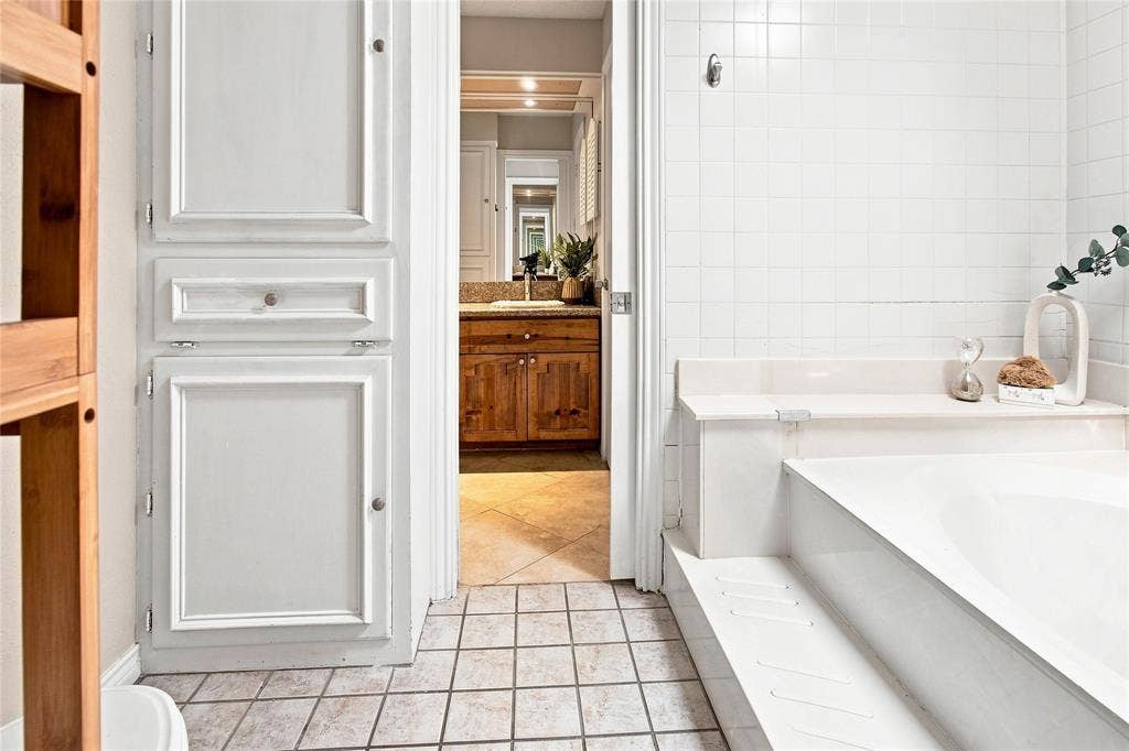 1417 Sun Valley Drive, Garland, TX 75043 Primary bathroom with built-in cabinetry, ceramic tile flooring, and integrated bathtub with steps