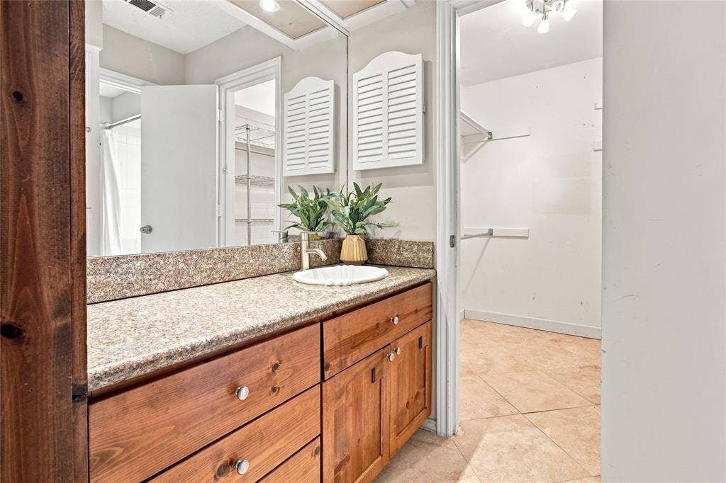 1417 Sun Valley Drive, Garland, TX 75043 Primary bathroom with a granite-style countertop, undermount sink, and wood-finish cabinetry
