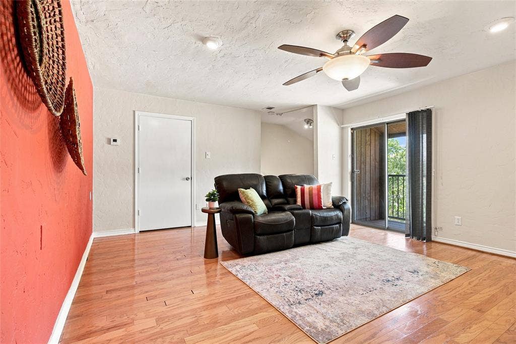 1417 Sun Valley Drive, Garland, TX 75043 Hardwood-finish flooring, ceiling fan with integrated lighting, sliding glass door with balcony, textured walls, and recessed lighting