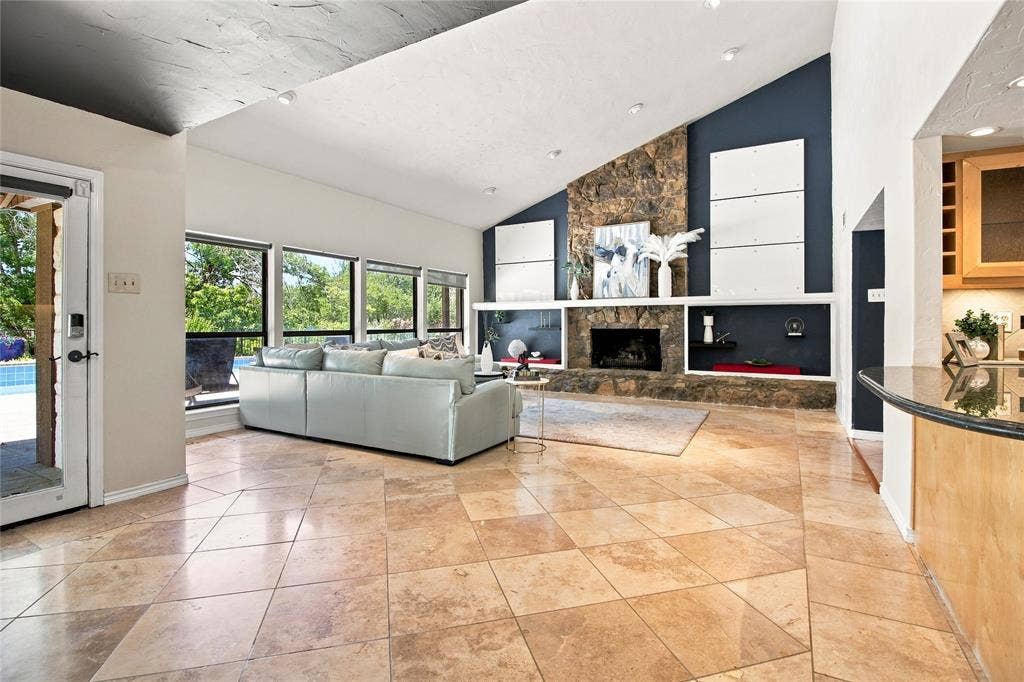 1417 Sun Valley Drive, Garland, TX 75043 Vaulted ceilings, a stone fireplace, large pane windows, and tiled flooring