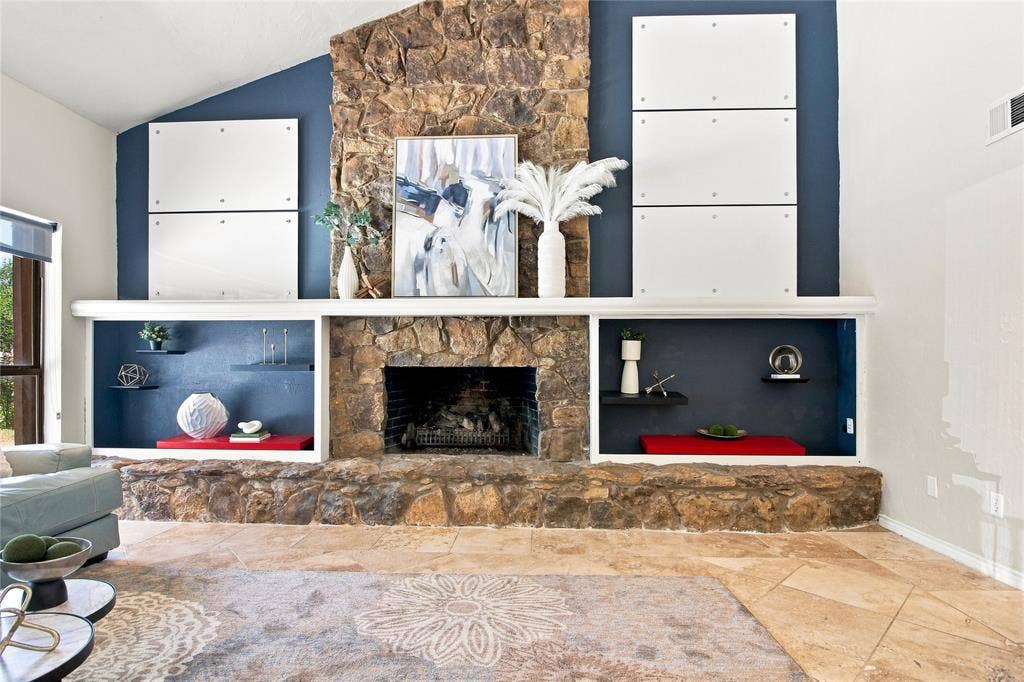 1417 Sun Valley Drive, Garland, TX 75043 Stone fireplace featuring a deep mantle with built-in shelving, a raised hearth, and stone-finish flooring