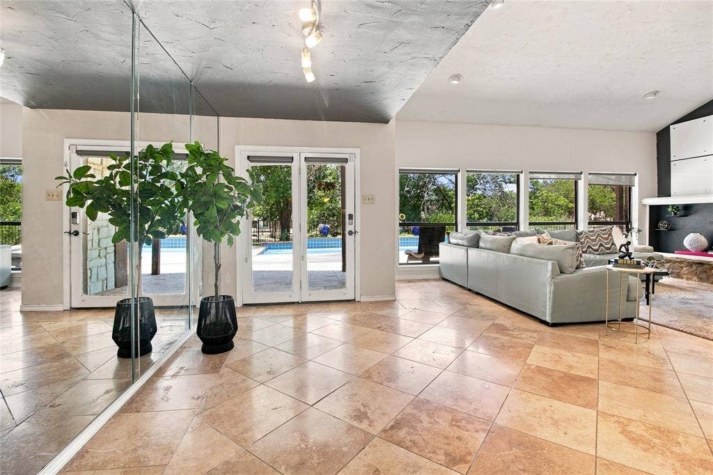 1417 Sun Valley Drive, Garland, TX 75043 Living room with tile floors, mirrored wall, and stone fireplace