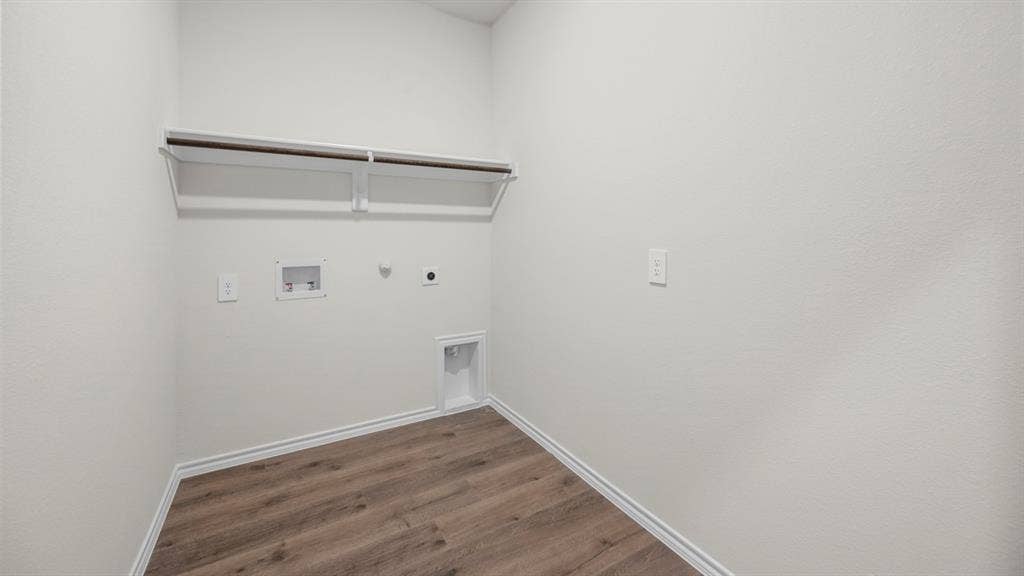 5033 Shumard Drive, Lindale, TX 75771 Wood-finish flooring, white walls, and built-in shelving with hanging rod