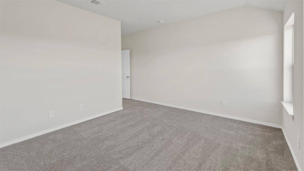 219 Yates Street, Bullard, TX 75757 Neutral wall finishes, textured carpeting, vaulted ceiling, and a prominent window