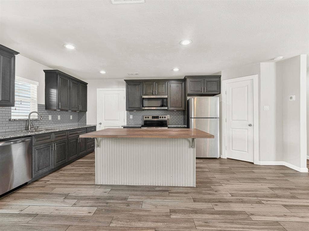 The kitchen has an oversized island with a breakfast bar and an extra large pantry
