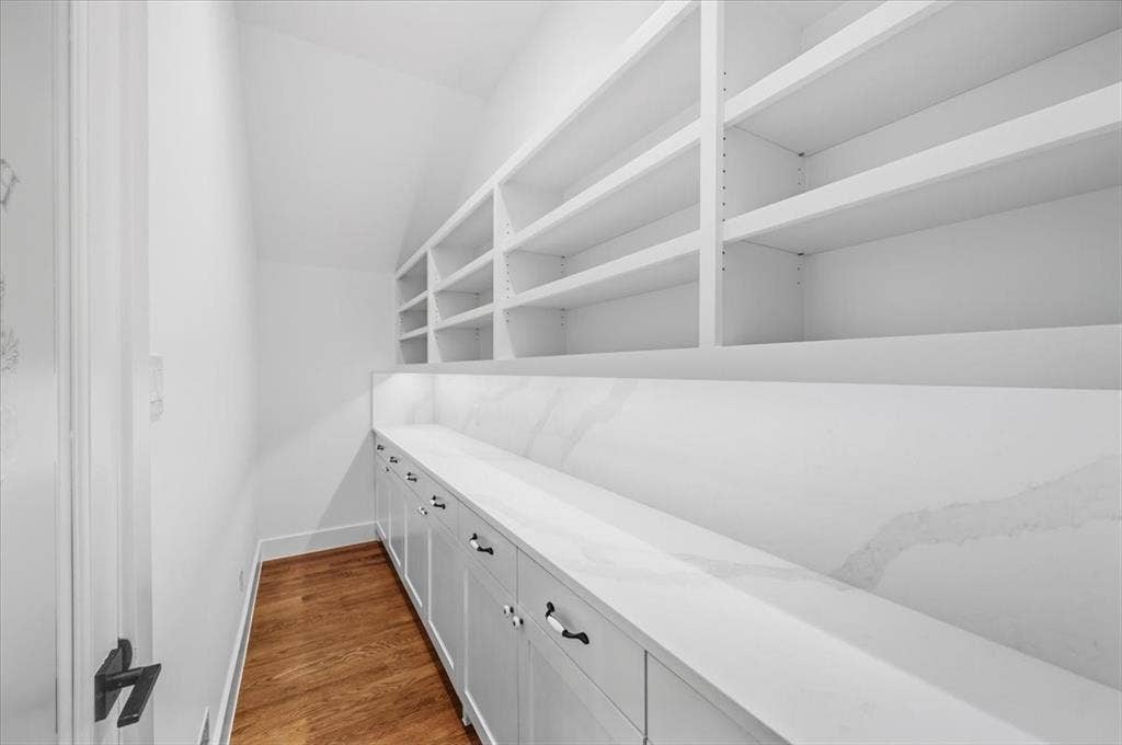 4320 Concho Street, Dallas, TX 75206 Built-in shelving, lower cabinetry with drawers, white countertop, white backsplash, and wood-finish flooring
