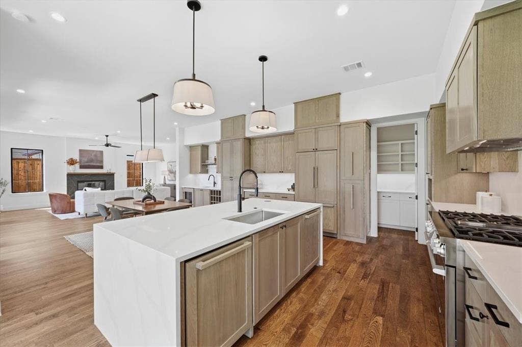 4320 Concho Street, Dallas, TX 75206 Gourmet kitchen featuring a large island, integrated appliances, natural wood cabinetry, a built-in pantry, and wood-finish flooring