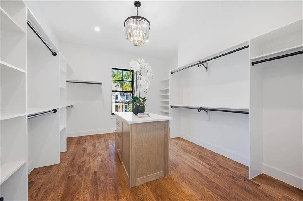 4320 Concho Street, Dallas, TX 75206 Hardwood flooring, custom built-in shelving, center island with stone countertop, recessed lighting, and a crystal chandelier