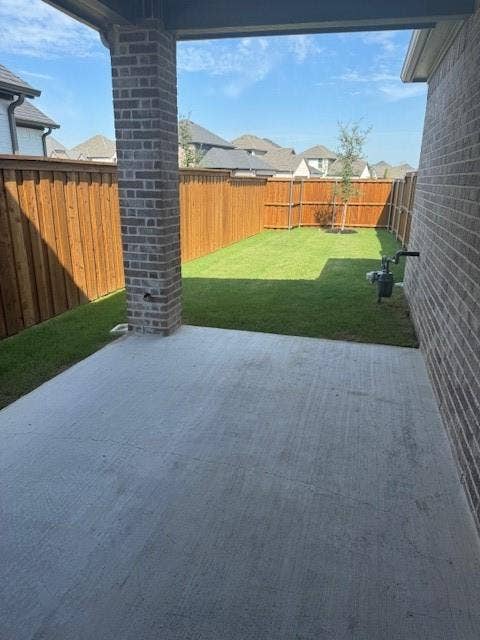 109 North Sky Drive, Celina, TX 75009 Covered patio with brick column, concrete flooring, and an expansive lawn area
