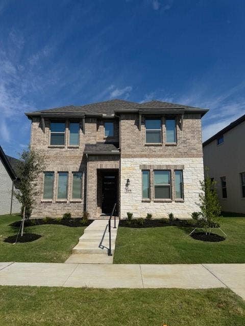 109 North Sky Drive, Celina, TX 75009 Two-story exterior featuring brick and stone cladding, multiple windows, a prominent entry, and a manicured lawn