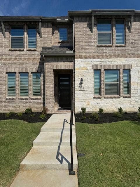 109 North Sky Drive, Celina, TX 75009 Two-story facade with mixed brick and stone cladding, multiple windows with blinds, front entry door, and a concrete walkway with a handrail