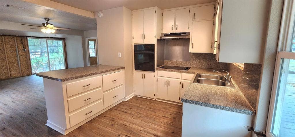 2016 Gavin Road, Tool, TX 75143 Kitchen with white cabinetry, built-in oven, integrated cooktop, double basin sink, and vinyl flooring