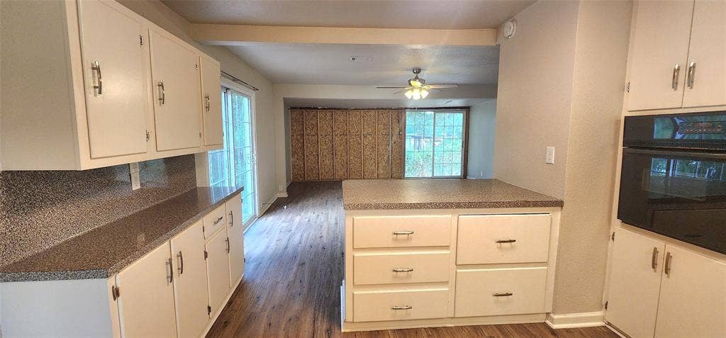 2016 Gavin Road, Tool, TX 75143 Kitchen featuring white cabinetry with silver-tone hardware, a built-in oven, and a peninsula with countertop seating