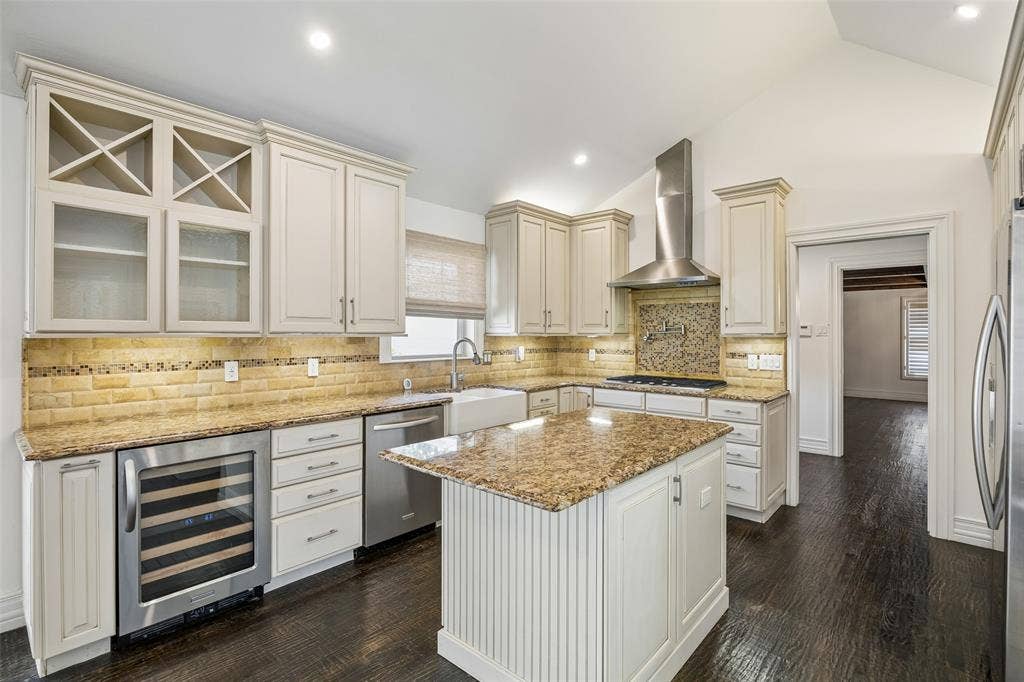 5610 Forest Lane, Dallas, TX 75230 Kitchen with light-toned cabinetry, granite countertops, and a tile backsplash