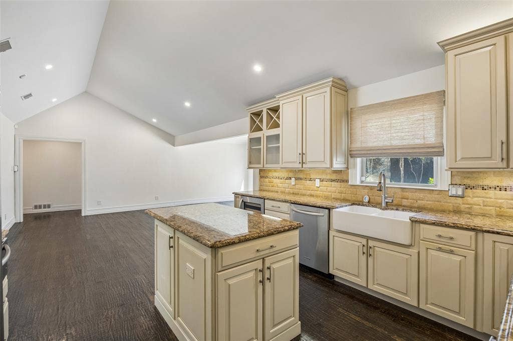 5610 Forest Lane, Dallas, TX 75230 Kitchen island with integrated cabinetry, farmhouse sink, stainless steel dishwasher, and under-cabinet lighting
