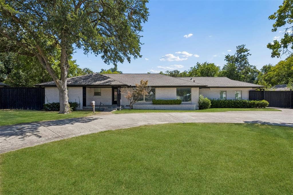 5610 Forest Lane, Dallas, TX 75230 Single-story residence featuring a gray shingle roof and a light-colored brick exterior