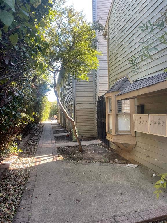 Exterior siding, concrete walkway with brick border, and bay window structure