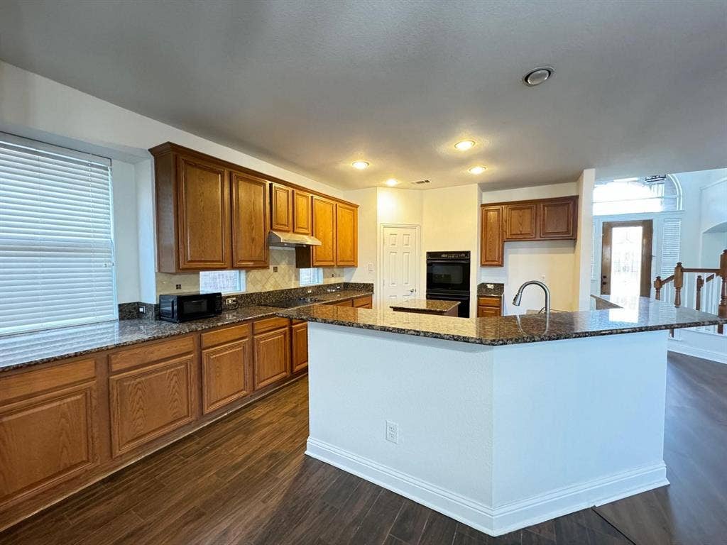 4531 Oak Shores Drive, Plano, TX 75024 Kitchen featuring wood-finish flooring, recessed lighting, wood cabinetry, granite countertops, and a built-in oven